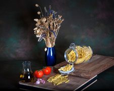 Still life wall art of pasta, tomatoes, olive oil and garlic